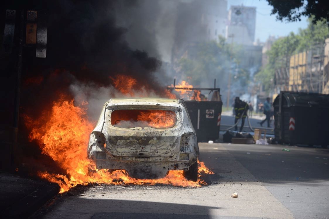 FRENTE A FRENTE. Manifestantes se enfrentan a las fuerzas policiales mientras un auto arde durante las marchas contra la reforma previsional, que se intentó debatir este jueves en la Cámara de Diputados. (Andrés D’Elía)