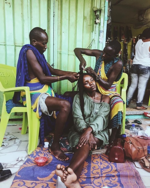 forafricans - A woman gets her hair braided by Maasai men....