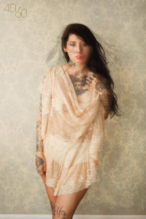 foto de tatuajes una mujer en un vestido de pie delante de una pared