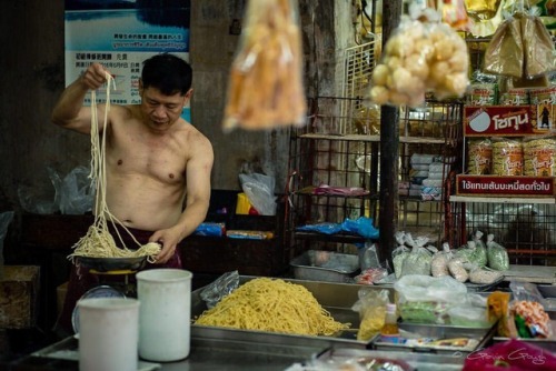 In Bangkok’s Chinatown district, a man prepares noodles...