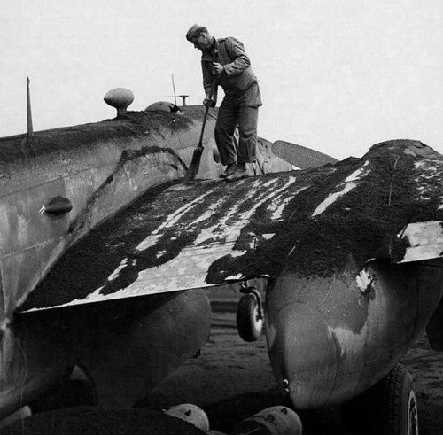 warhistoryonline - Crew member sweeping ashes off a B-25 of the...
