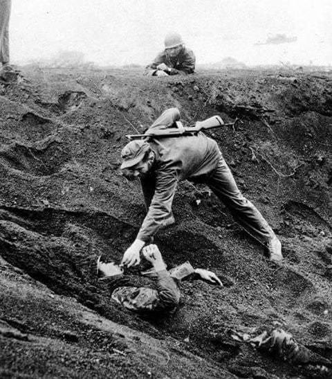 American Marine gives a Japanese soldier a cigarette after learning he had buried himself and played dead for nearly two days. Iwo Jima, 1945. Via