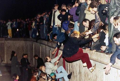 historicaltimes - West Berliners as they climb the Berlin Wall,...