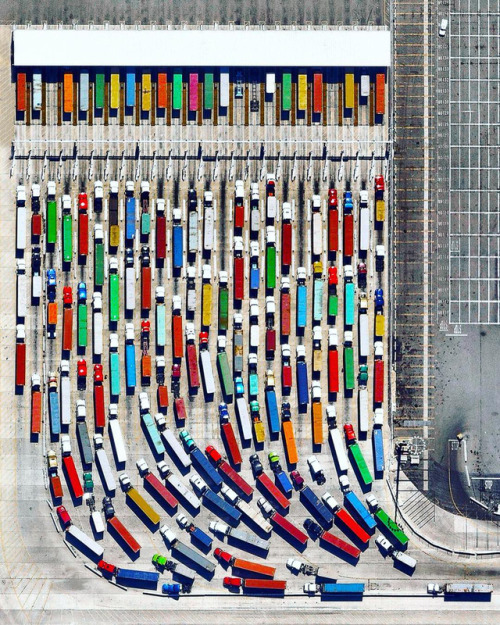 dailyoverview - Long-haul trucks wait in line to exit the Port of...