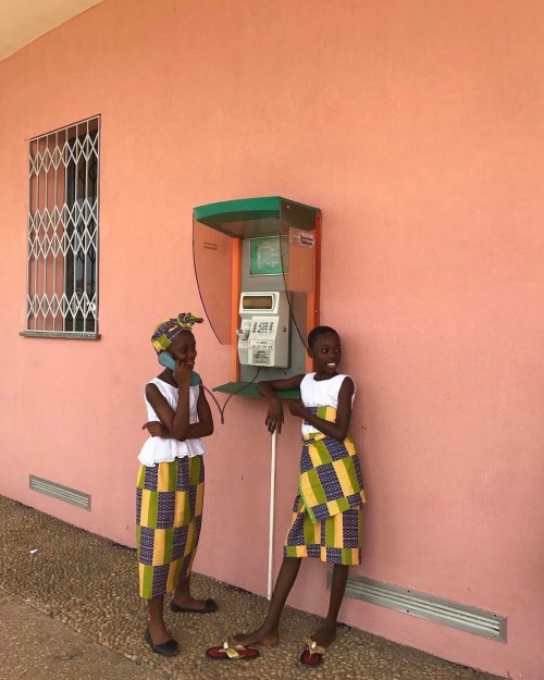 forafricans - Two girls by a phone booth beside St Paul’s Cathedral. Abidjan, Cote D'Ivoire....