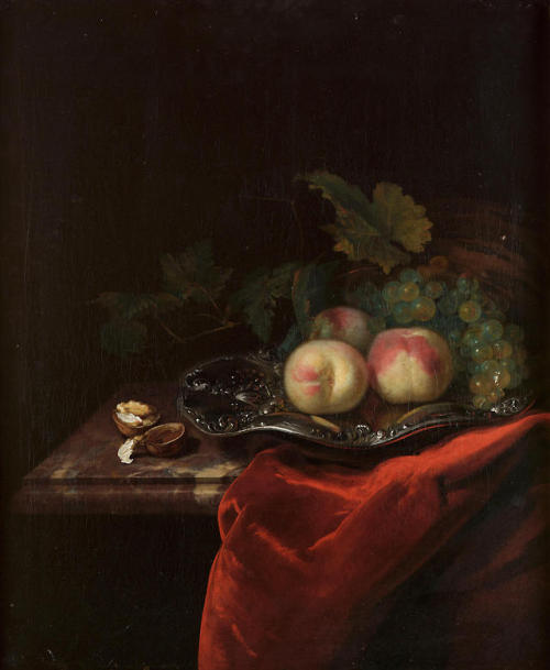 Peaches and grapes on a silver salver with walnuts on a...