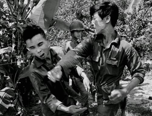 greasegunburgers - A South Vietnamese soldier, punches the face of...