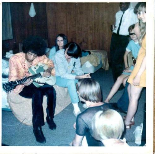 historicaltimes - Jimi Hendrix playing guitar, being watched by...