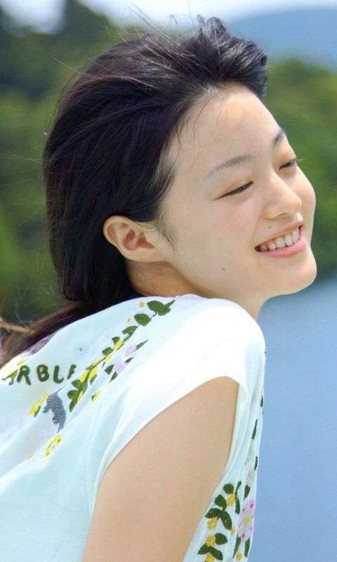 白いシャツを着て風を感じている小林涼子の画像