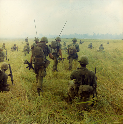 vietnamwarera - 327th Infantry troops moving across a field...