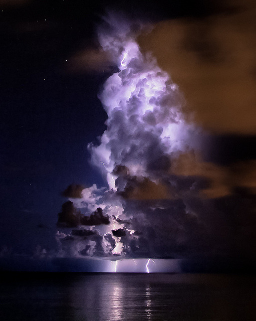 coiour-my-world: “ Dark & Stormy by mrjones131 on Flickr. Grand Cayman ” A sizzle lights up the night sky. Followed by thunder up so high. The black clouds rumble in dismay. Crumbling like figures of clay. Red soon joins the purple light. Gearing up...