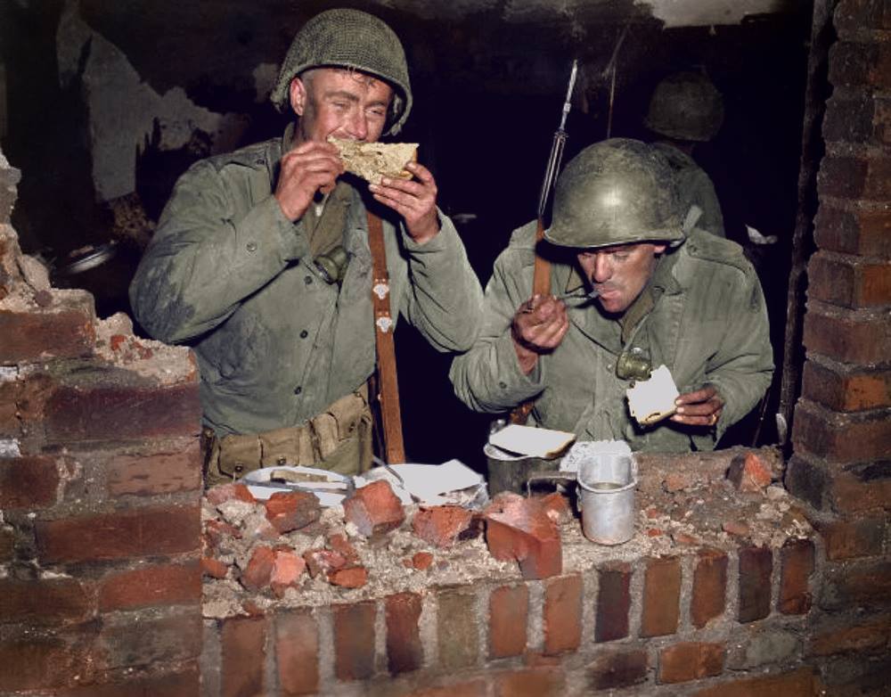 Пехотинцы американской армии быстренько перекусывают во время обстрела этого дома.