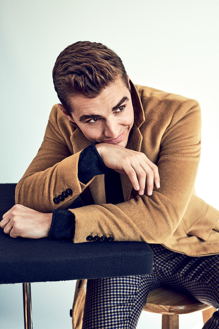 Dave Franco close-up wearing a tan Brooklyn Tailors overcoat over a black sweater