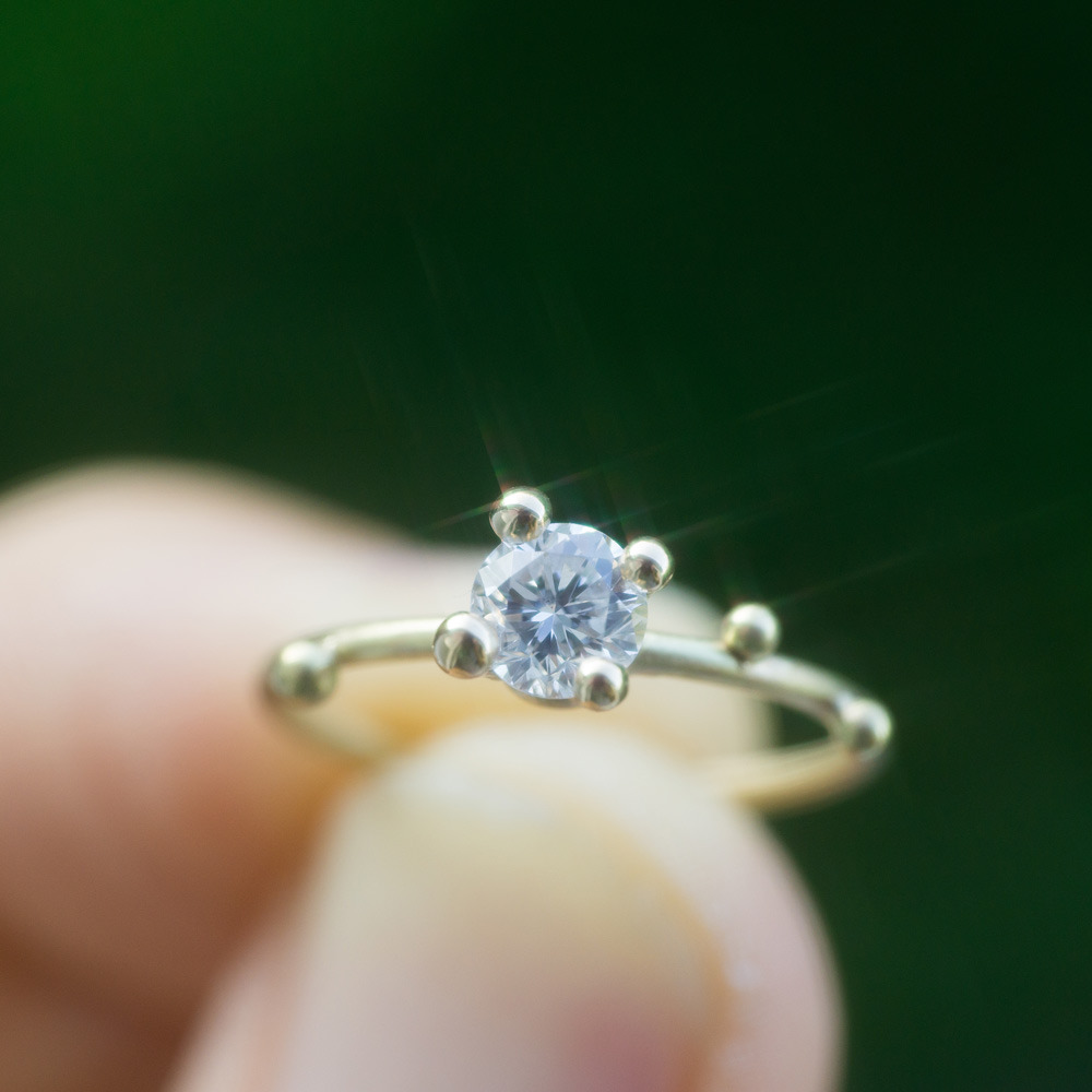 オーダーメイドの婚約指輪　ゴールド、ダイヤモンド　屋久島の緑バック　輝き
