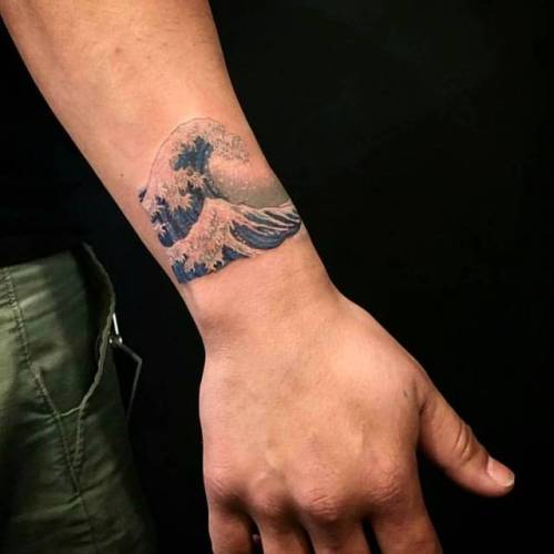 The Great Wave Off Kanagawa inspired tattoo on the left