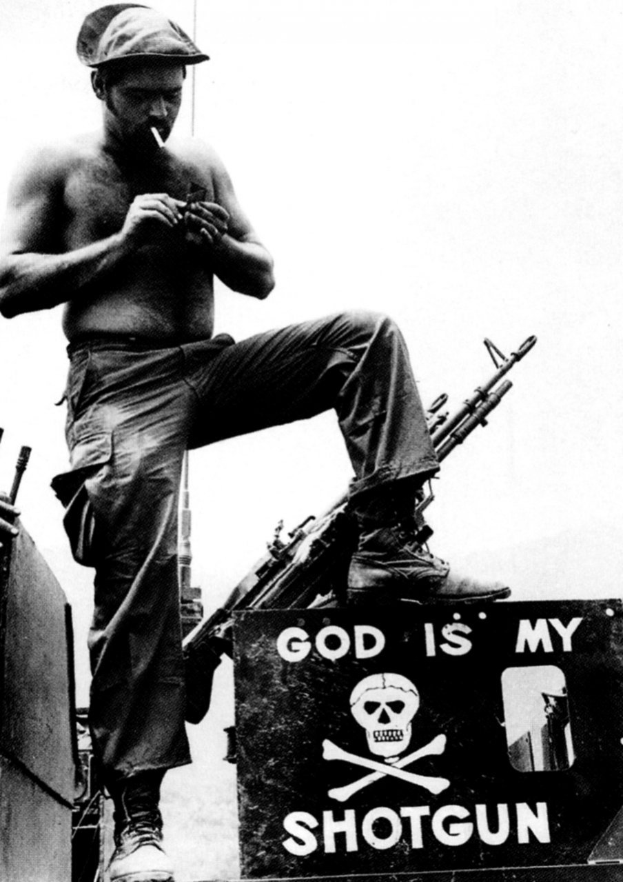 godshufflesherfeet:
“An American soldier, lighting a cigarette in front of his machine gun atop a vehicle, stands above a sign serving as testament to his battlefield beliefs.
Khe Sanh, South Vietnam, April 12, 1971
”