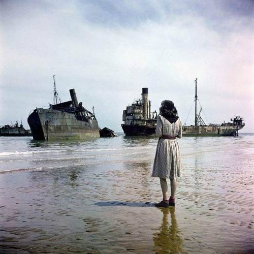 classy-dames - historicaltimes - A woman standing on Omaha Beach...