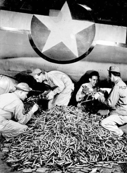warhistoryonline - Removing spent shell casings from a B-17 after...