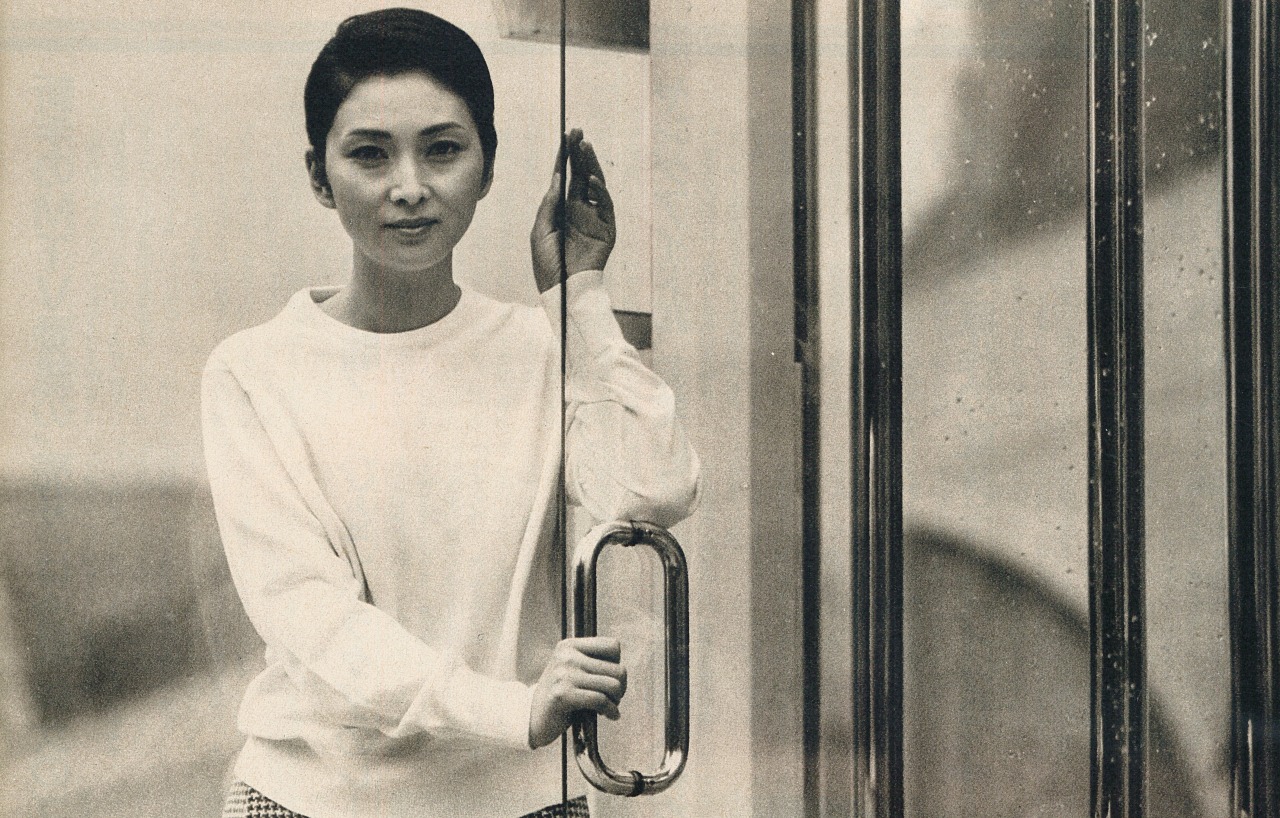 ガラス戸に手をかけているスウェットを着た梶芽衣子の画像