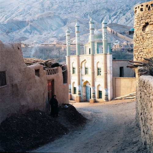 muslimerican-blog - Woman and mosque in Xinjiang Province,...